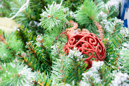 Christmas ball on tree. Closeup on Christmas tree decoration over festive backgroundの写真素材