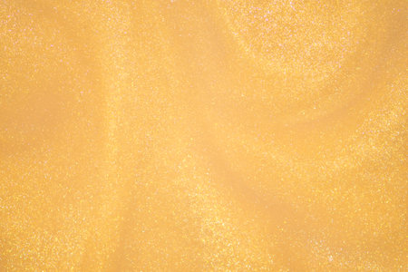 Golden glitter dust on dark background.の写真素材