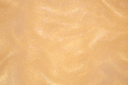 Golden glitter dust on dark background.の写真素材
