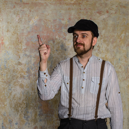 Excited man pointing a great idea adjusting his suspendersの写真素材