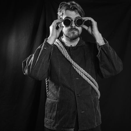 Working in a black robe corrects welding goggles . black backgroundの写真素材