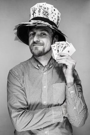 man in the hat of playing cards on gray backgroundの写真素材