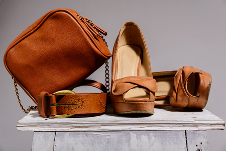 brown female bag with shoes and belt  isolated on gray backgroundの写真素材