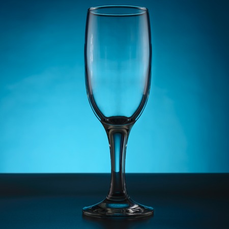 Empty champagne glass isolated on blueの写真素材