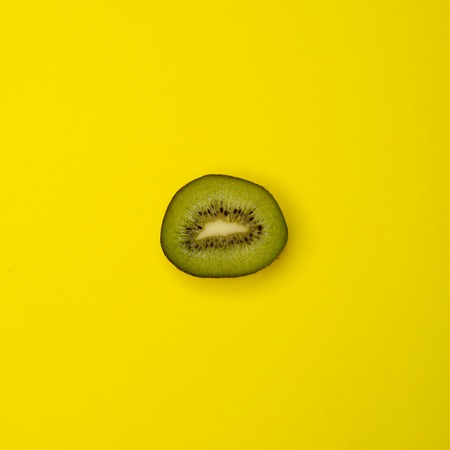 Cut kiwifruit on yellow backgroundの写真素材