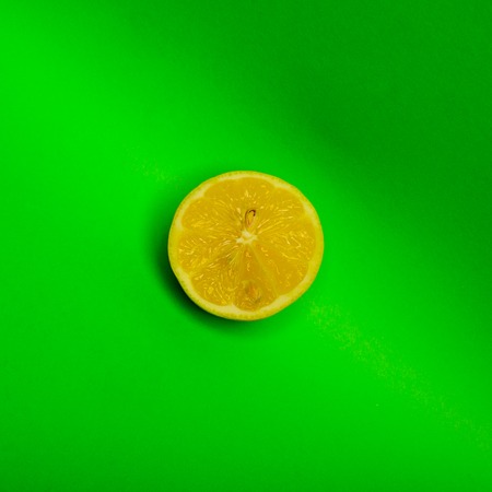 A Slice of lemon shot on a green backgroundの写真素材
