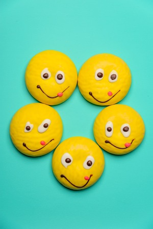 Round cookie with smiling face isolated over blueの写真素材