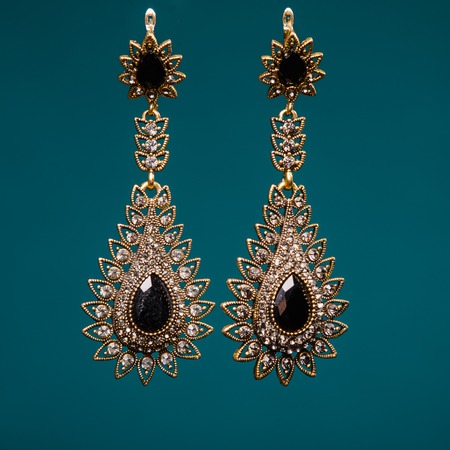 silver earrings with black stones  on blue backgroundの写真素材