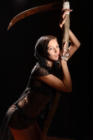 Girl in a black lace smock with a scythe of death. conceptの写真素材
