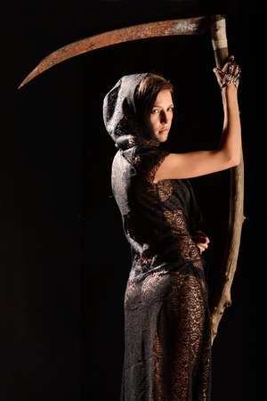 Girl in a black lace smock with a scythe of death. conceptの写真素材