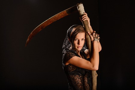 Girl in a black lace smock with a scythe of death. conceptの写真素材