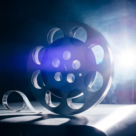 Movie reel of film in retro in the blue smoke on a dark backgroundの写真素材