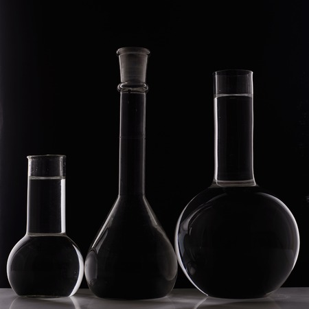 Laboratory equipment, three glass flask on black background.の写真素材