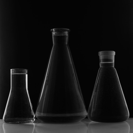 Laboratory equipment, three glass flask on black background.の写真素材