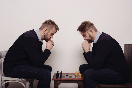 man playing chess against himself. thinks over the stepの写真素材
