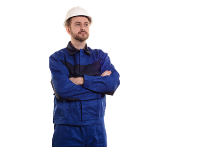male construction worker in a helmet stands with his arms crossed isolated on whiteの写真素材