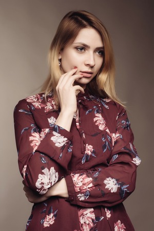 Portrait of a beautiful woman in a dress with floral pattern. Fashion photoの写真素材