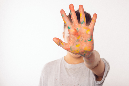 teenage girl covers her face with her right palm in paintの写真素材