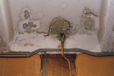 Big wet spots and cracks on the ceiling of the domestic house room after heavy rain and lot of water - Imageの写真素材