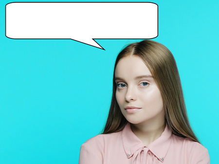 Portrait of a young pensive girl with a babble talk over her head on cyan background. - imageの写真素材