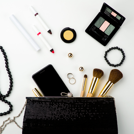 Fashionable female accessories brushes smartphone lipstick eyeshadow and black bag. Overhead of essentials for any girl - Imageの写真素材