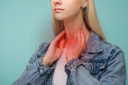 A young girl has a sore throat. Thyroid problems - Image