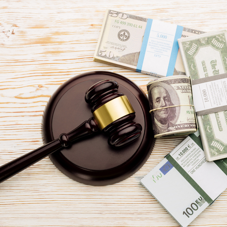 Top view Judge's gavel and packs of dollars and euro banknotes on a white wooden table.The concept of growing national debt- imageの写真素材