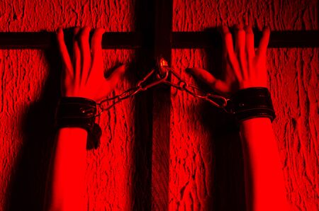 BDSM outfit for adult sex games. Close-up of female hands handcuffed bondsge to the bars - imageの写真素材