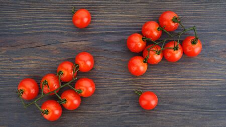 Ripe cherry tomatoes on a twig on a dark woden background - imageの写真素材