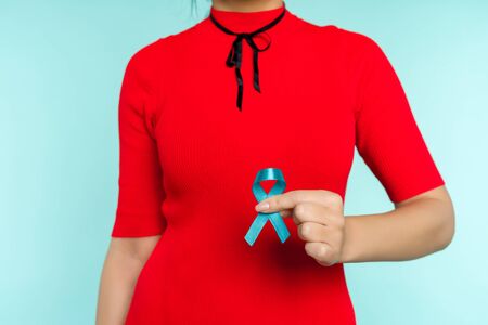 Asian woman holding a blue ribbon in her hand. Symbol Child abuse problem and prostate cancer - imageの写真素材