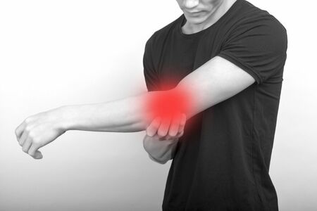 male having elbow pain in injured arm on background - image
