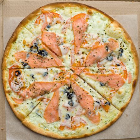 Closeup of pizza with red fish. salmon or trout, cheese, black olivesの写真素材