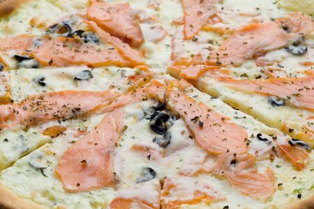Closeup of pizza with red fish. salmon or trout, cheese, black olivesの写真素材