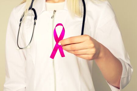 Female Doctor Holds Pink Ribbon, International Breast Cancer Day October 7 - Image tonedの写真素材