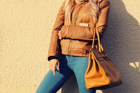 Young stylish woman in black trendy outfit with big bag in hand street lookの写真素材