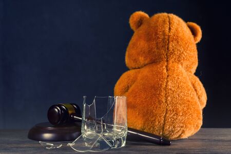 Teddy bear, judge's hammer, broken glass. The concept of deprivation of parental rights or divorce due to alcoholism. - imageの写真素材