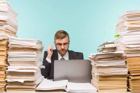 Business executive holds a video conference in the office and piles of paperwork, he is overloaded with work - imageの写真素材