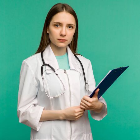 Happy smiling young female doctor with clipboard, isolated over background - imageの写真素材