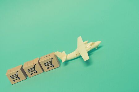 White model airplane lands on blue background from most famous countries around the world with boxes of goods behind. An idea of air freight transportation, global parcel forwarding, international shippingの写真素材