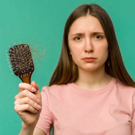 Tired overworked young intern woman working with a laptop in an office - imageの写真素材