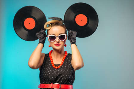 A photo of glamorous pin-up girl holding vinyl LP in hand - imageの写真素材