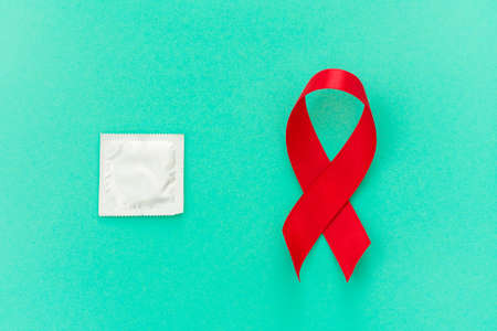Red ribbon with a condom on a blue background - imageの写真素材