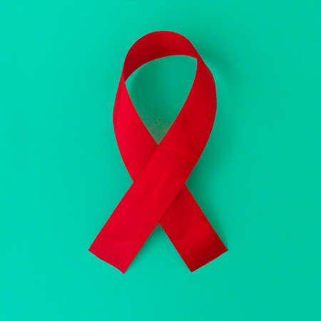 Red color ribbon isolated awareness on blue background for World aids day campaign.の写真素材