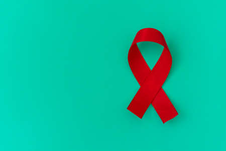 Red color ribbon isolated awareness on blue background for World aids day campaign.の写真素材