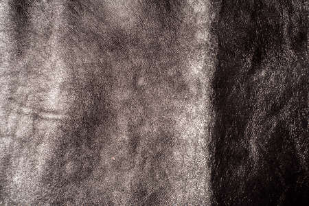 Black leather background with rich texture detail. close-up of black leather. A blurred background.