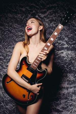 Funny young woman girl in white shirt posing isolated on gray wall background studio portrait. People sincere emotions lifestyle concept. Mock up copy space. Screaming in megaphoneの写真素材