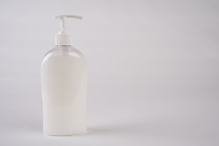 White unbranded dispenser bottle isolated on white background, cosmetic packaging mockup with copy spaceの写真素材