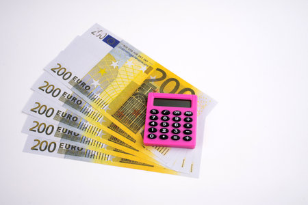 Pink calculator and euro on a white background.の写真素材
