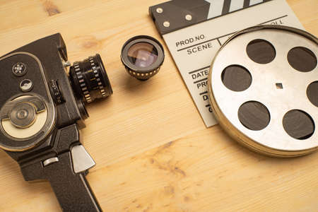Movie clapper, film reel and camera on wooden background, top viewの写真素材