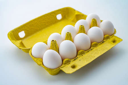 Open egg box with ten eggs isolated on white background
